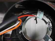 Feed wires through the enclosure between Motor Mounting Clamp and the blower wheel opening